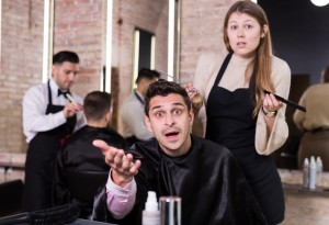Unpleasantly surprised man with regretting woman hairdresser in