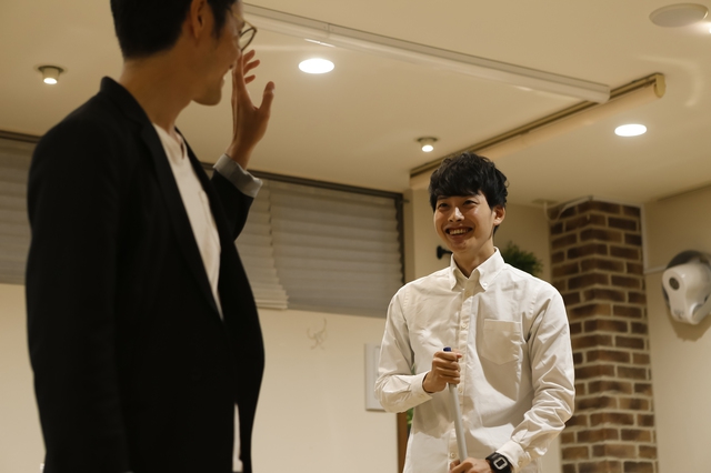 笑顔で先輩スタイリストに接する男性アシスタント