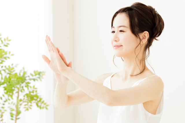 ハンドケアをする笑顔の女性